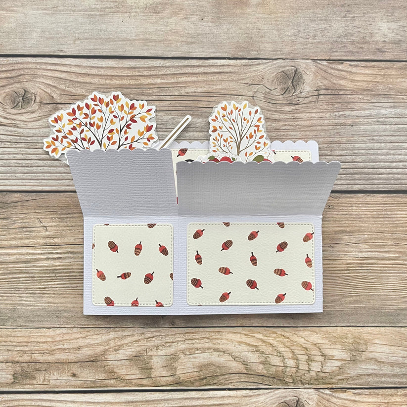 Card with autumn-themed design on a wooden surface