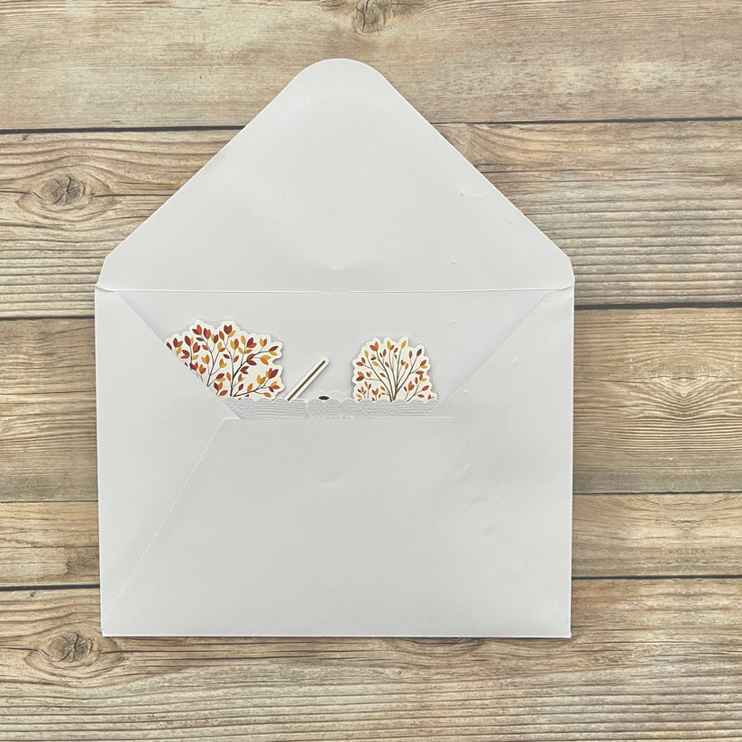 White envelope with floral design on a wooden surface