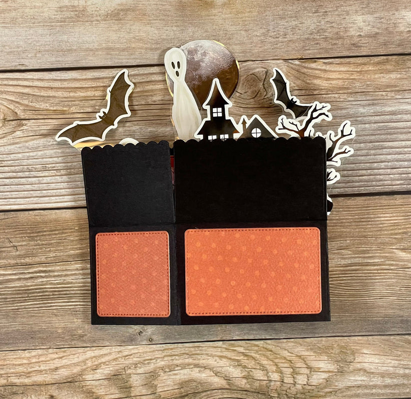 Halloween-themed card with cut-out elements on a wooden background