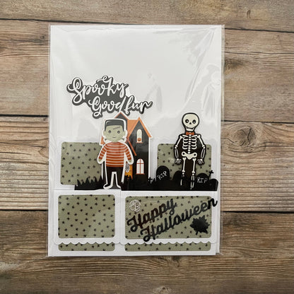 Halloween-themed card with cartoon characters and text on a wooden surface