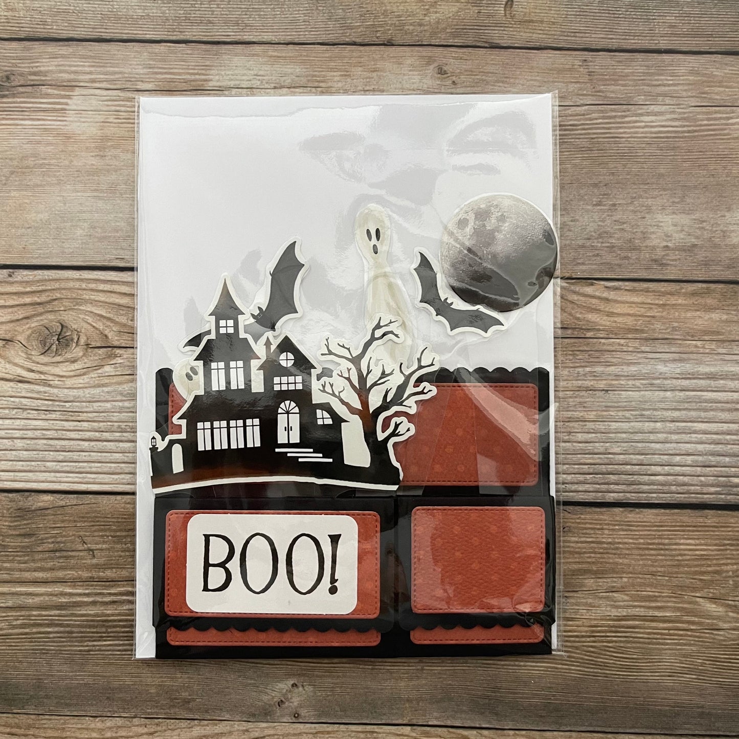Halloween-themed product packaging with ghost, moon, and 'BOO!' text on a wooden surface