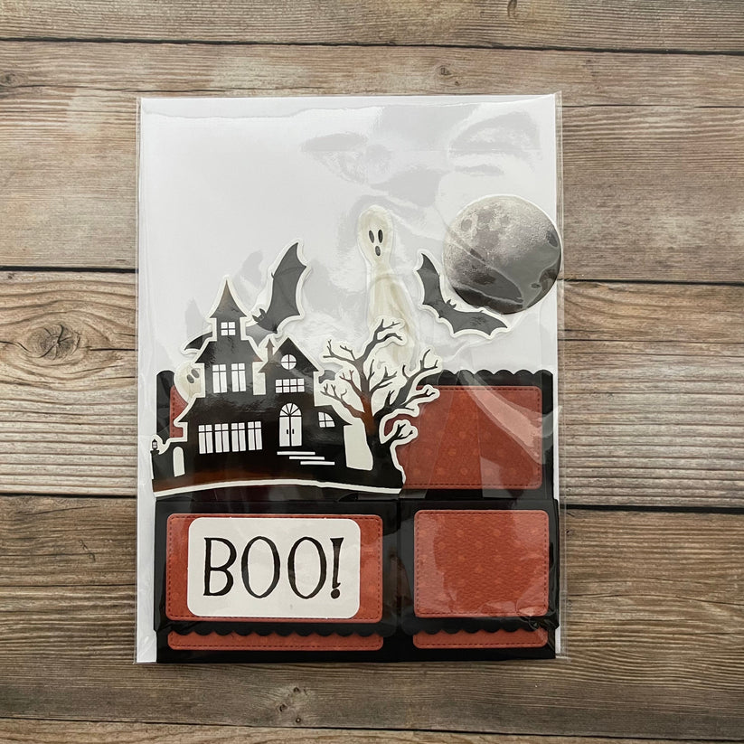 Halloween-themed product packaging with ghost, moon, and 'BOO!' text on a wooden surface