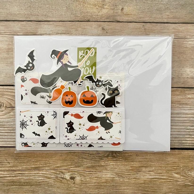 Halloween-themed card with stickers on a wooden surface