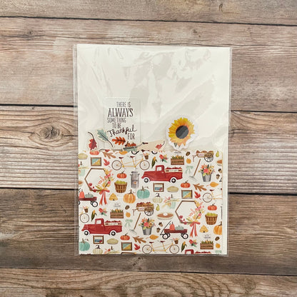 Decorative greeting card with autumn-themed illustrations and text on a wooden surface