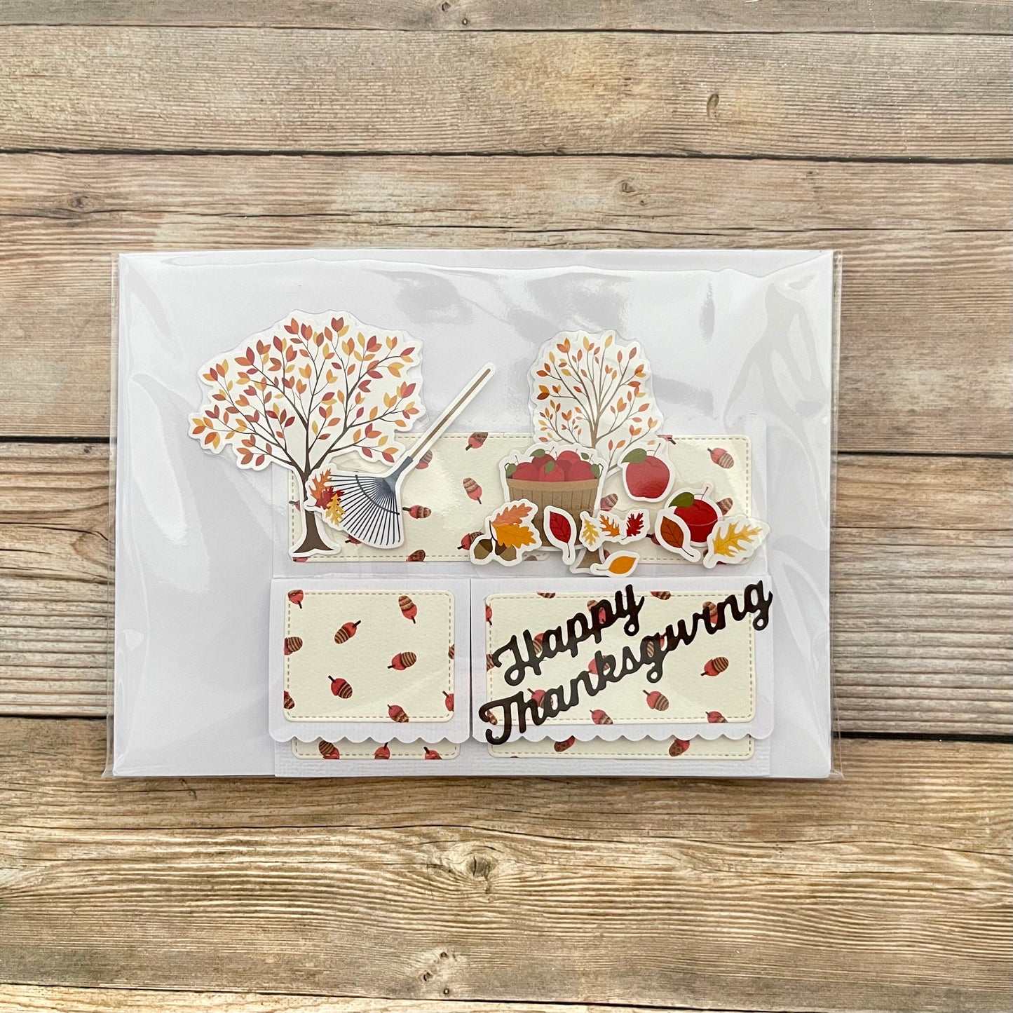 Thanksgiving-themed card with autumnal designs on a wooden surface