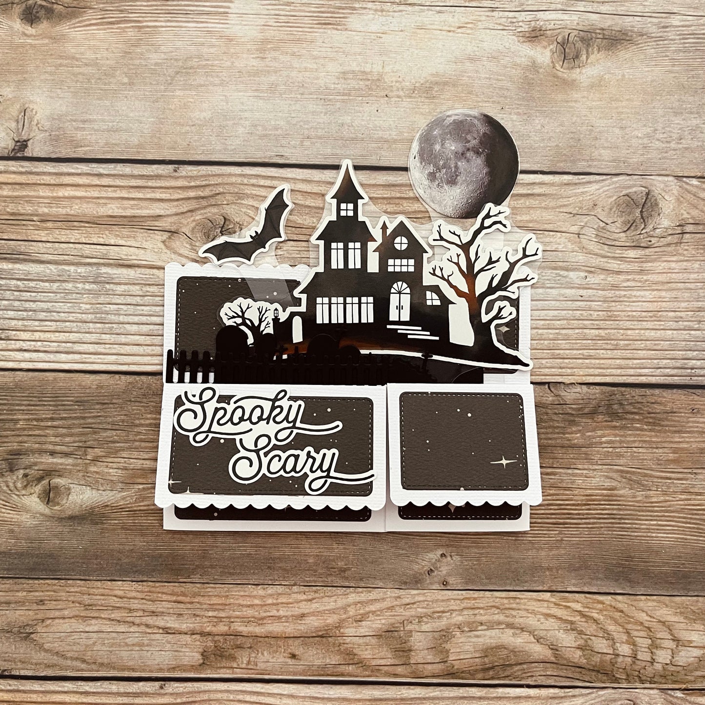 Halloween-themed cutout with a haunted house design on a wooden surface