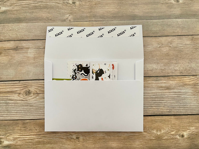 Envelope with a window showing a colorful card on a wooden surface