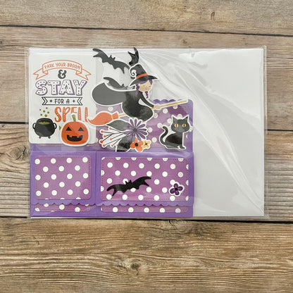 Halloween-themed card with stickers on a wooden surface