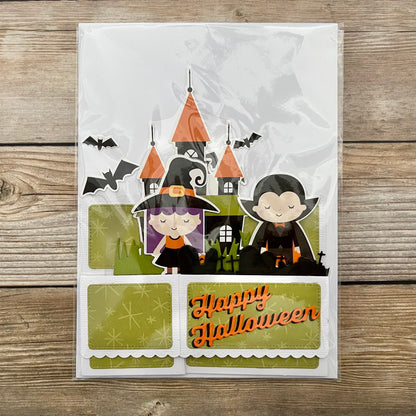 Halloween-themed card with cartoon characters and castle on a wooden surface