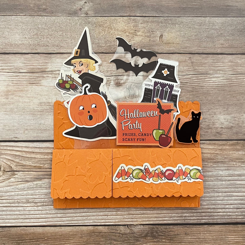 Halloween-themed card with cut-out elements on a wooden surface