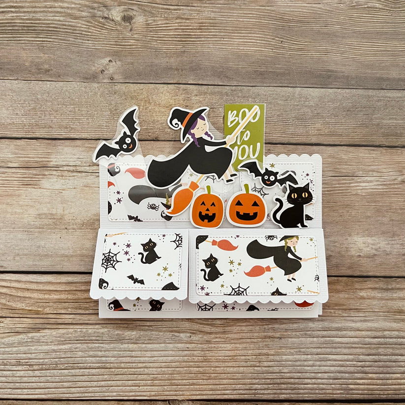 Set of Halloween-themed cards with witches, cats, and pumpkins on a wooden surface.