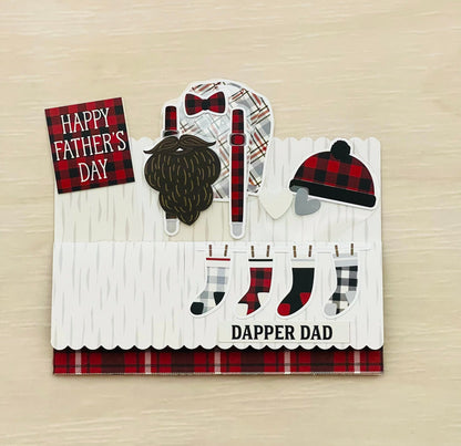 Father's Day pop-up card with plaid patterns, beard, hat, and socks on a wooden surface