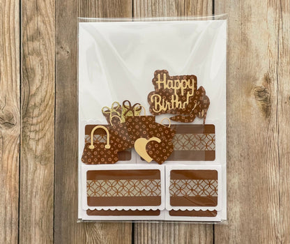 Decorative birthday card with brown and gold elements on a wooden surface