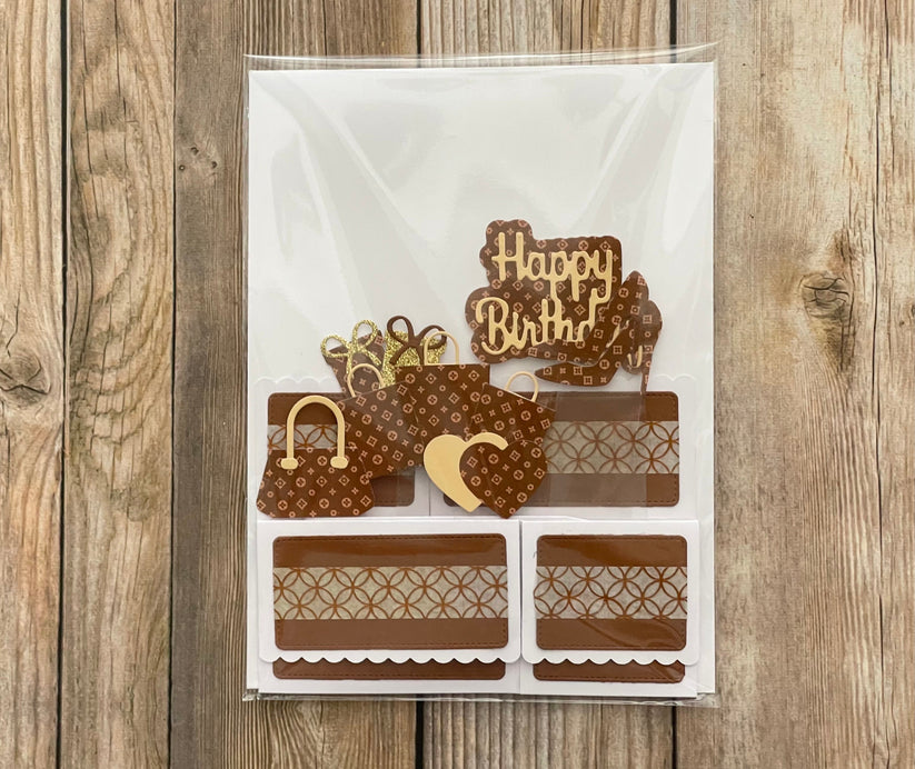 Decorative birthday card with brown and gold elements on a wooden surface