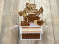 Pop-up birthday card with high heels, cake, and 'Happy Birthday' on a wooden surface