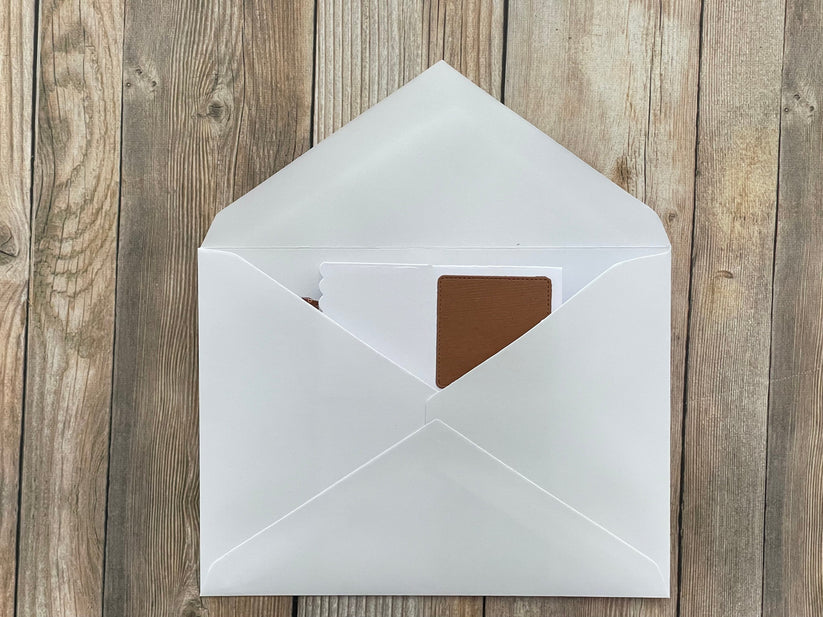 White envelope with a brown interior on a wooden surface
