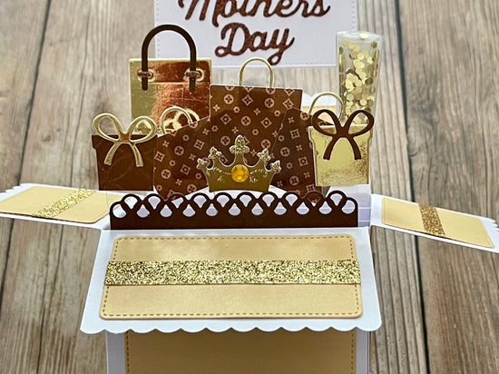 Pop-up card with shopping bags and 'Mother's Day' text on a wooden background