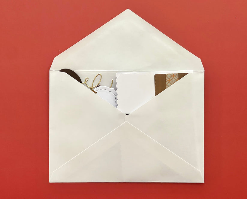 Open white envelope with stationery items on a red background