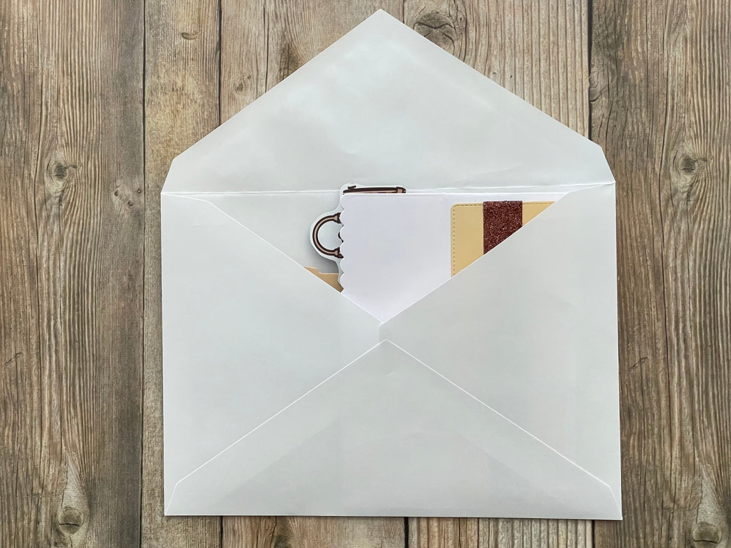 White envelope with a card inside on a wooden surface