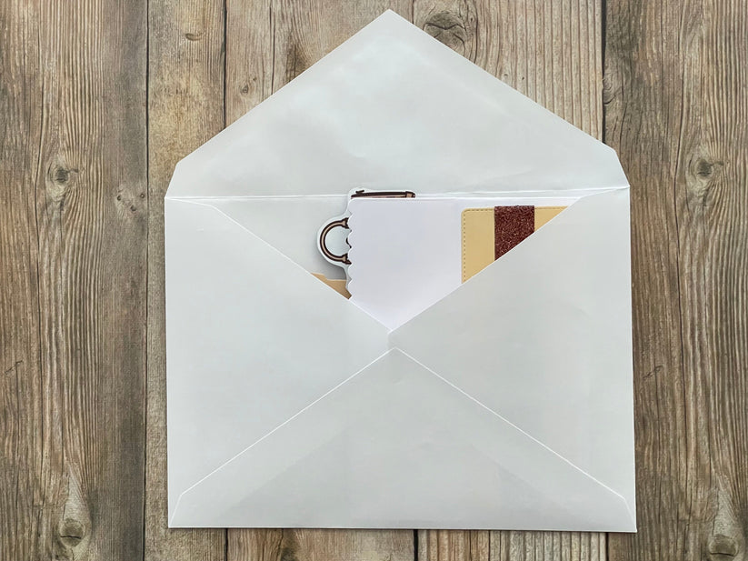 White envelope with a card inside on a wooden surface