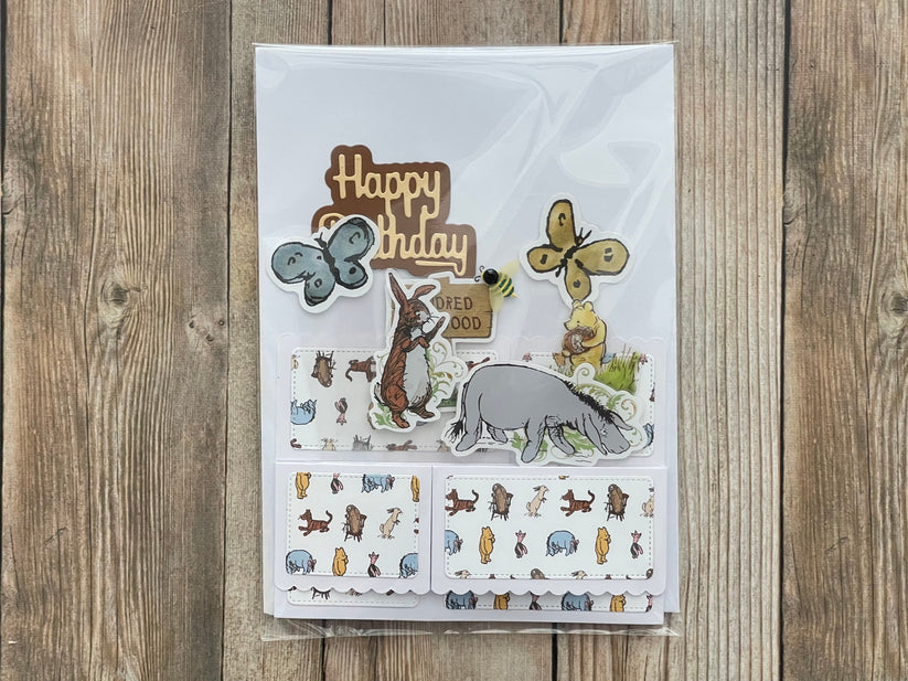 Children's birthday card with animal illustrations on a wooden surface