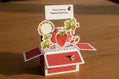 Open card with strawberry design and 'Have a berry Happy Birthday!' message on a light green background