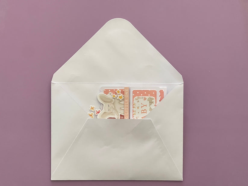 White envelope with a card featuring a cat illustration on a purple background