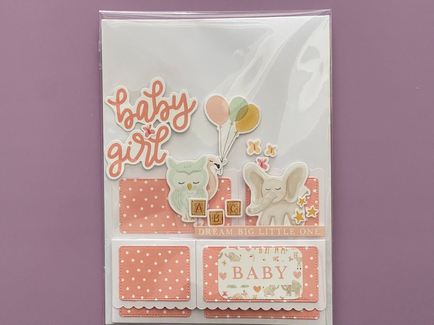 Baby girl themed card with cute illustrations and text on a purple background