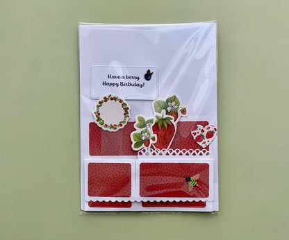 Greeting card with strawberry-themed design and 'Have a berry Happy Birthday!' text on a green background