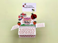 Mother's Day pop-up card with a ladybug and strawberry design on a light green background