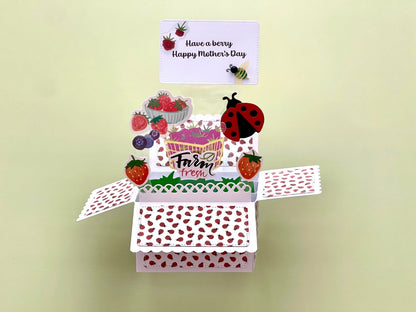 Mother's Day pop-up card with a ladybug and strawberry design on a light green background