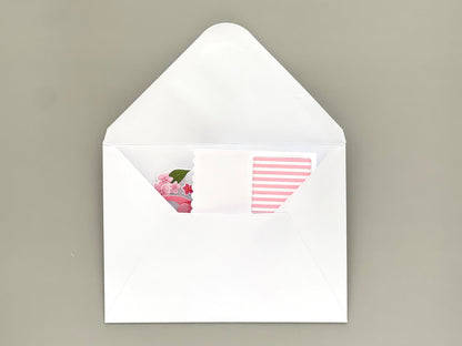 White envelope with floral design on the flap and striped pattern inside, on a beige background