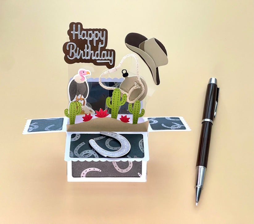 Pop-up birthday card with cowboy elements and a pen on a beige background