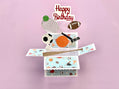 Pop-up birthday card with sports-themed elements on a pink background