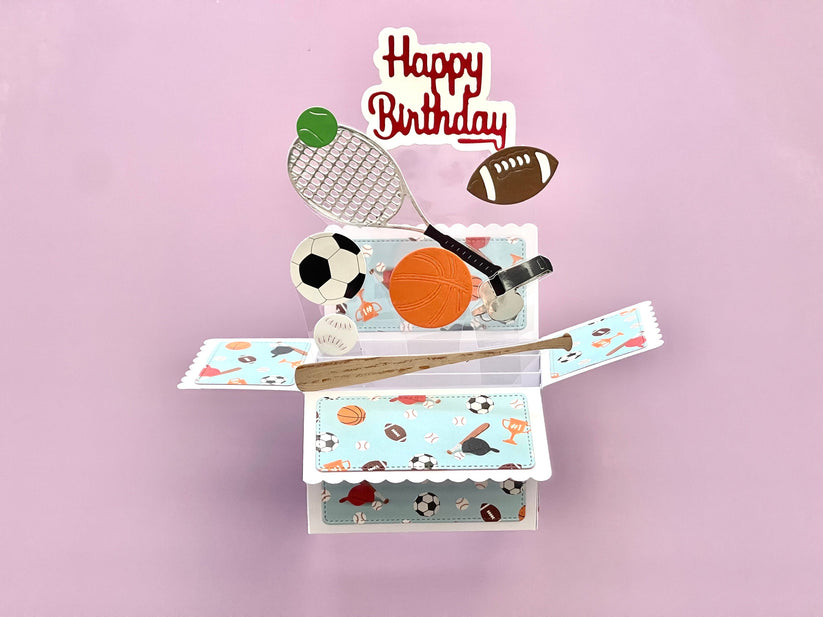 Pop-up birthday card with sports-themed elements on a pink background