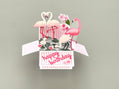 Greeting card with flamingo design and 'happy birthday' text on a gray background