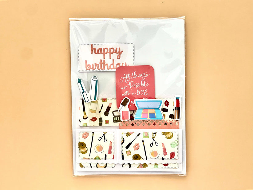 Greeting card with makeup illustrations and 'happy birthday' text on a beige background