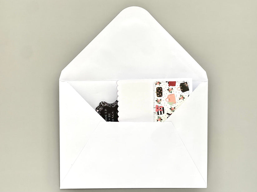 White envelope with a small card inside on a beige background