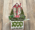 Christmas-themed card with a house and trees on a wooden surface