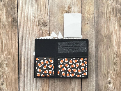 Black cardholder with candy corn pattern on a wooden surface