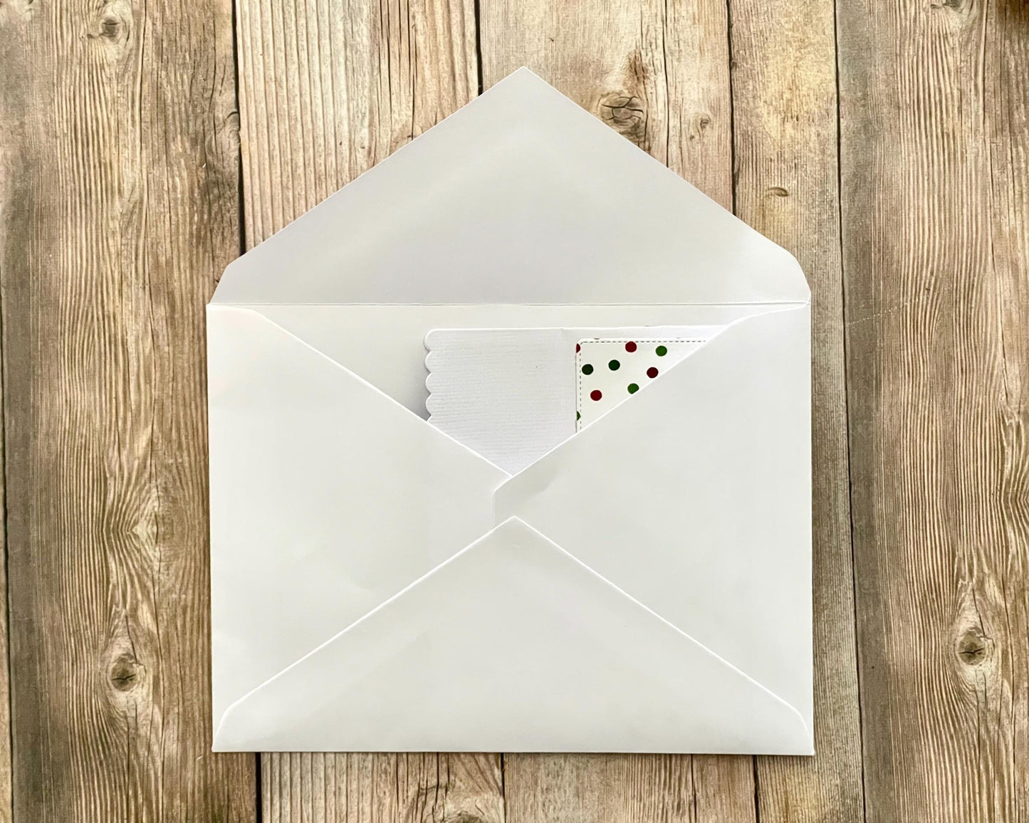 White envelope with a card inside on a wooden surface