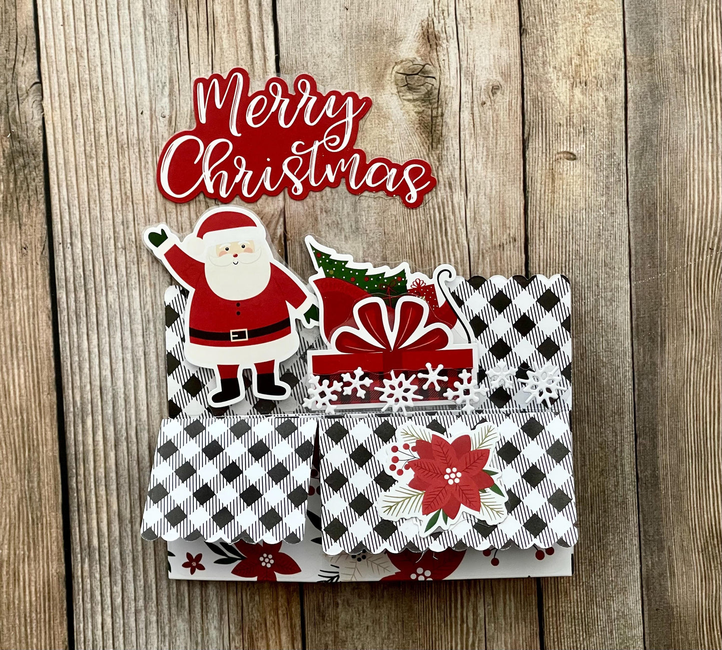 Christmas-themed card with Santa Claus and presents on a wooden surface