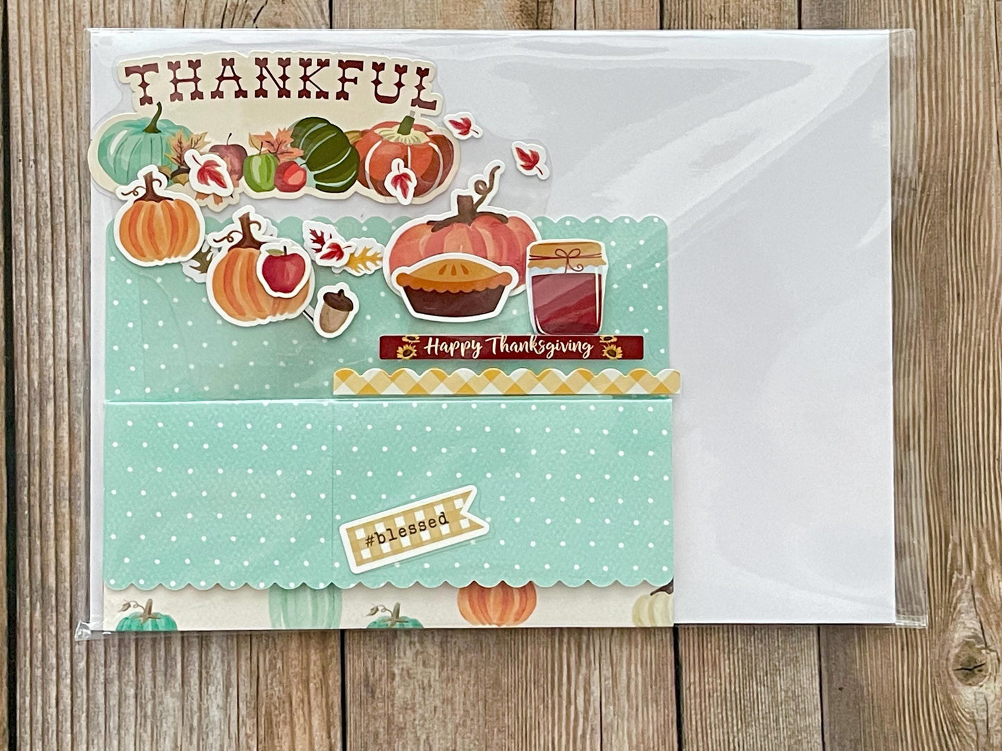 Thanksgiving-themed card with pumpkins, pies, and jars on a wooden surface