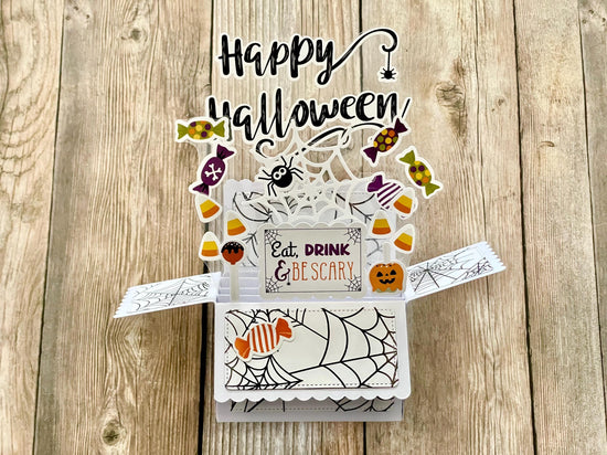 Halloween-themed pop-up card with candy-themed elements on a wooden surface