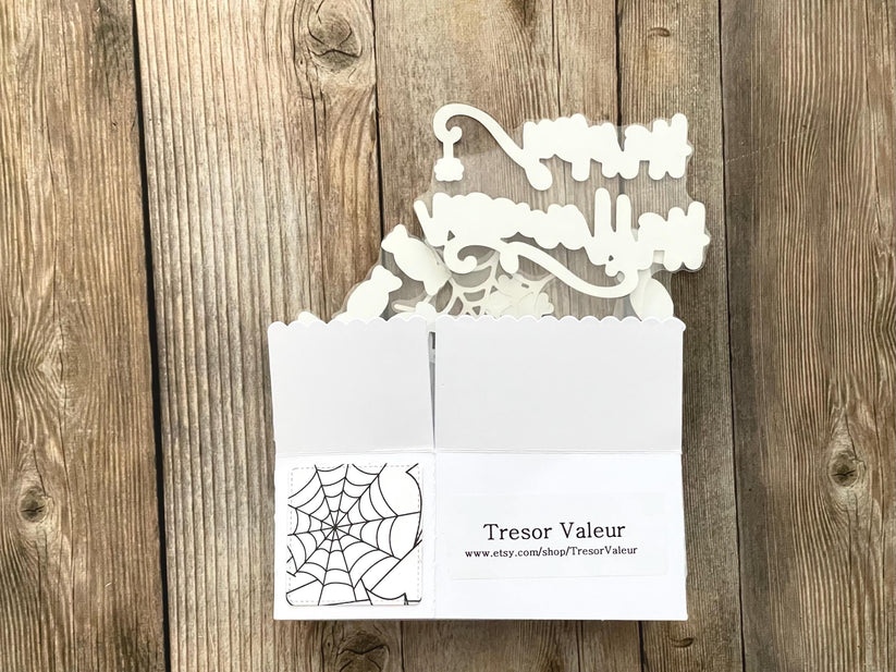 Decorative white card with cut-out design on a wooden surface