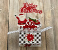 Christmas-themed pop-up card with Santa Claus and sleigh on a wooden background