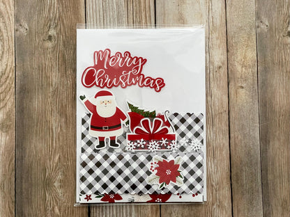 Christmas card with Santa Claus and gift on a wooden surface