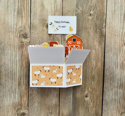 Fold-out card with farm-themed design on a wooden surface