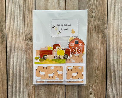 Children's birthday card with farm-themed design on a wooden surface