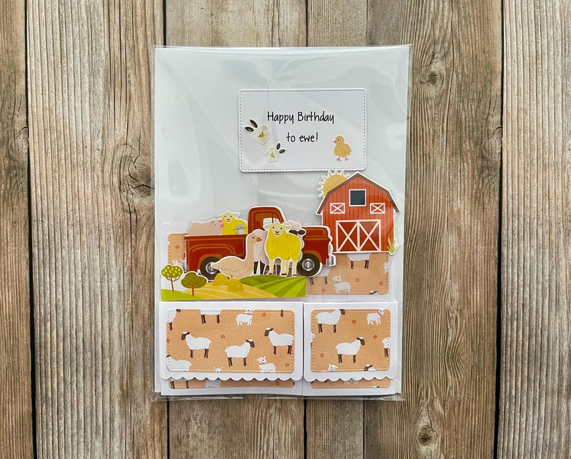 Children's birthday card with farm-themed design on a wooden surface